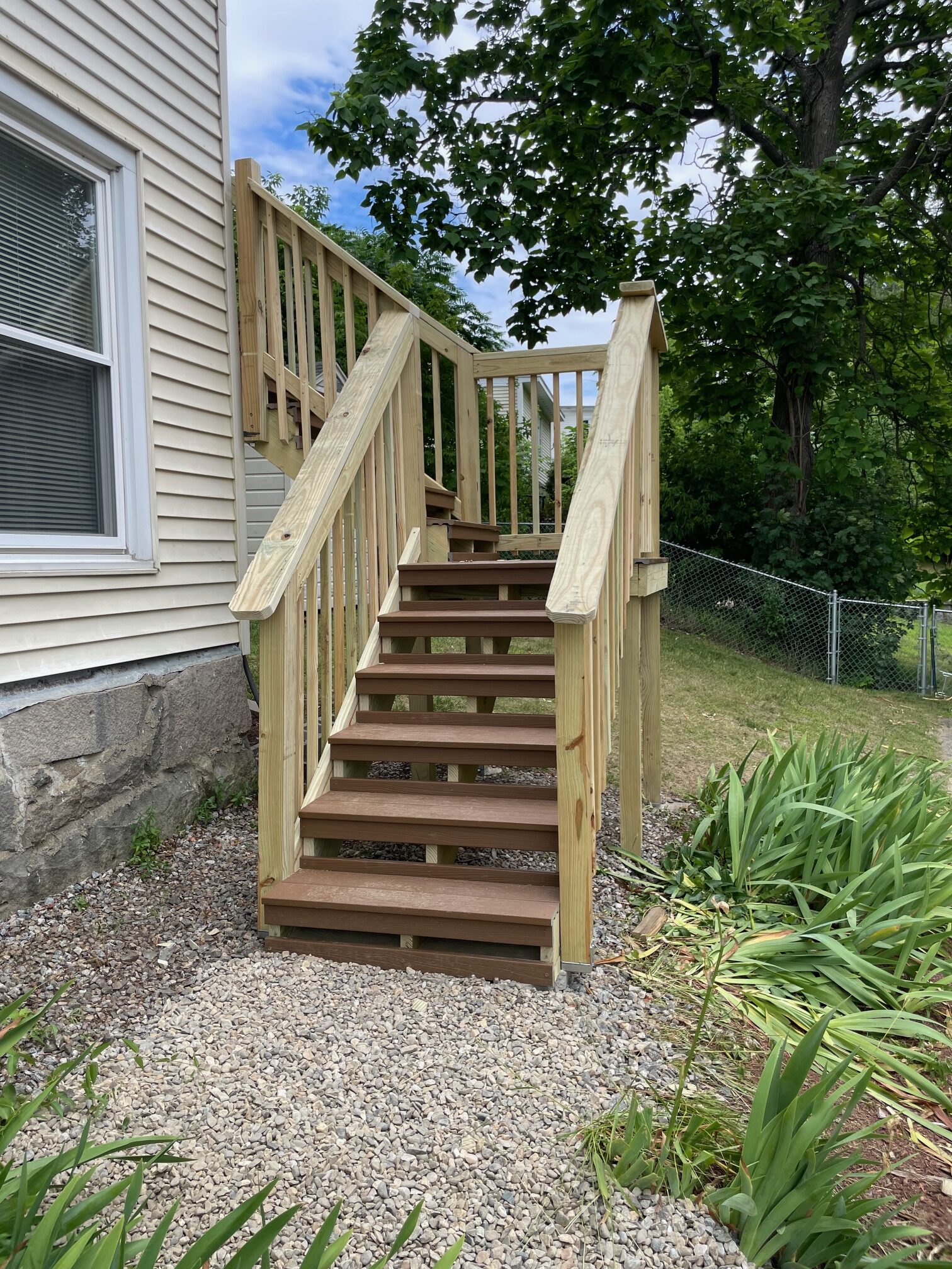 Outdoor staircase with wood railings beside a house