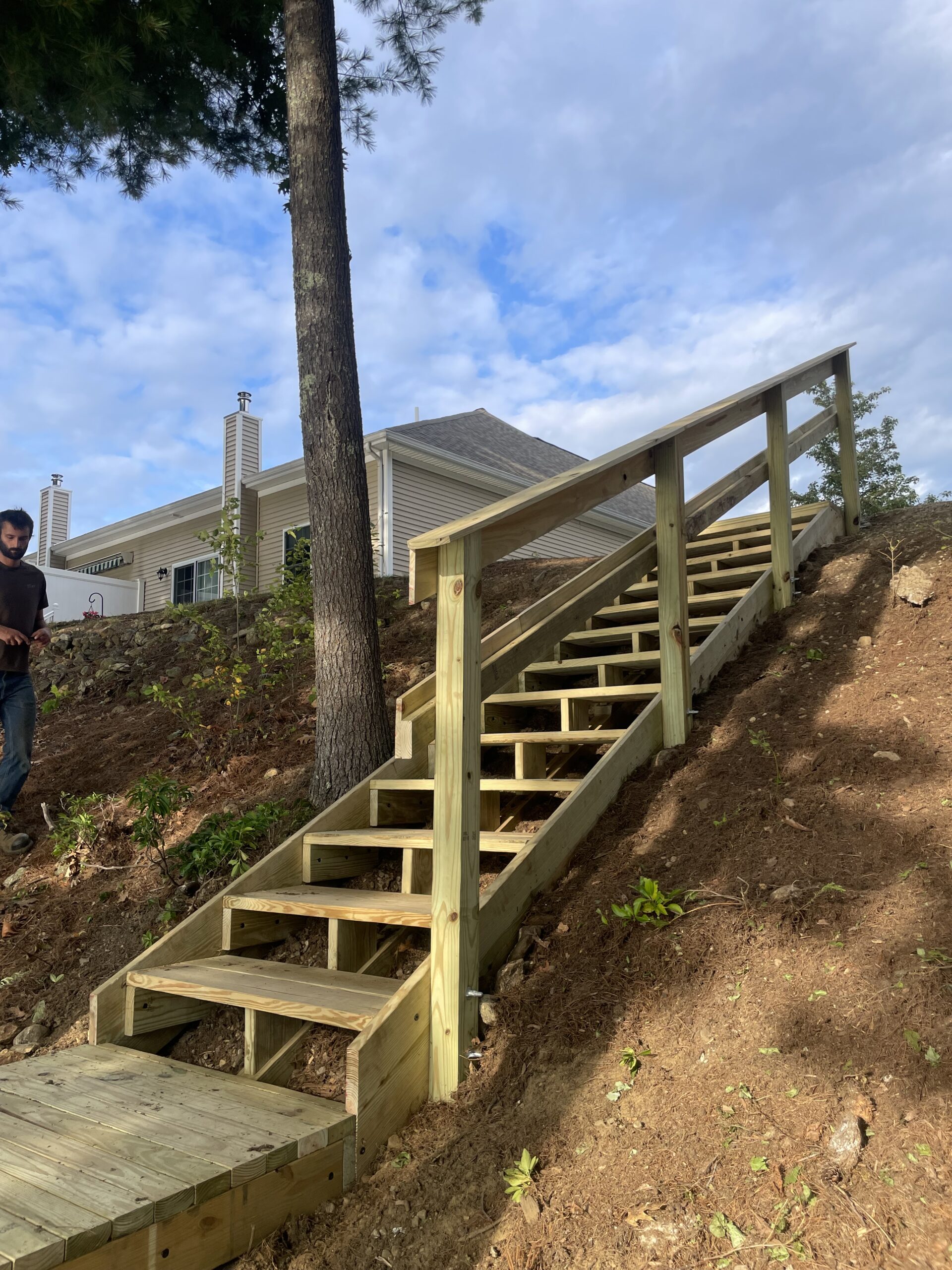 Wooden outdoor stairs and railings following a wooded slope